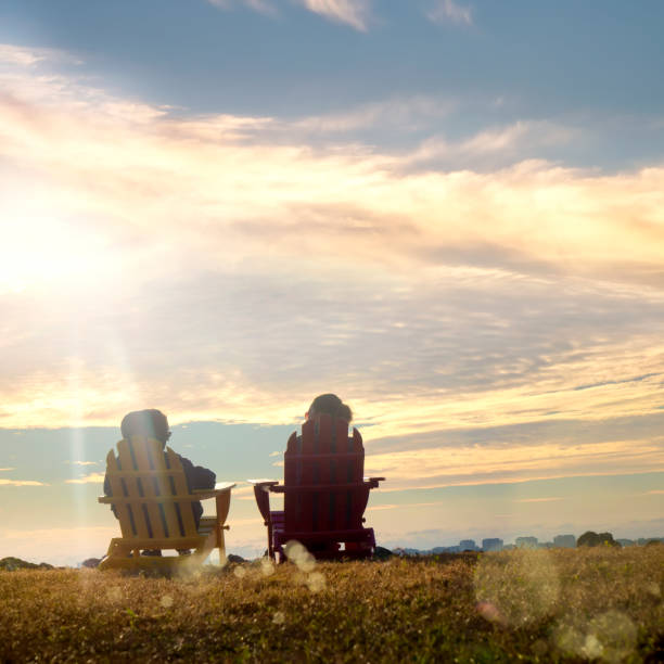 istock Two women sitting and watching sunset view in nature 2087740400