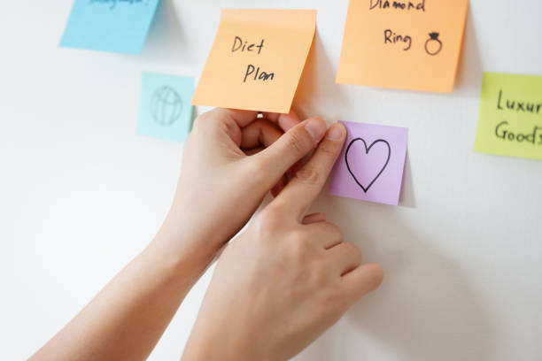 istock Asian woman sticking adhesive notes on wall 2087754954