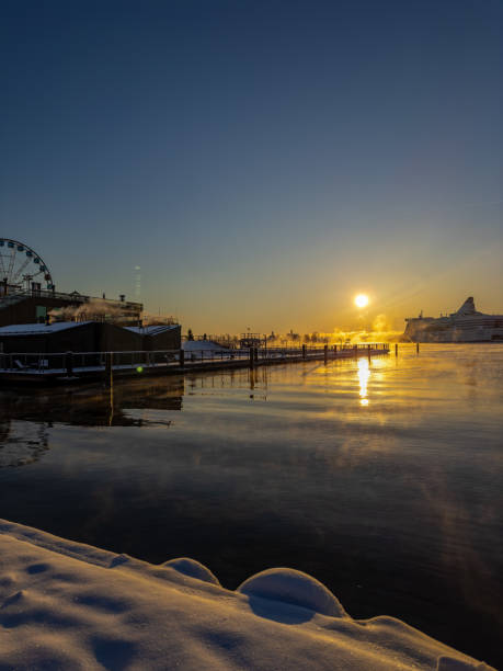 A ferry sits at the pier in Gothenburg, surrounded by icy waters. Blurry figures of people are seen departing, adding a sense of movement to the chilly atmosphere.