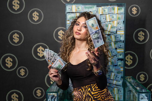 Young beautiful woman posing with US Dollar Banknotes