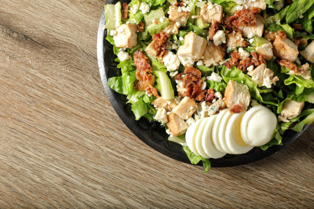 Woman's hands holding a bowl of salad and various healthy vegetables, healthy food.