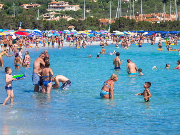 Porto Ottiolu, Sardegna. The wonderful beach of Porto Ottiolu crowded of people during the summer time. Sea in shades of turquoise blue. Tourist destination
