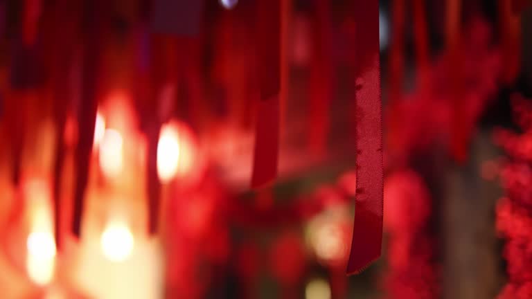 Closeup of red silk ribbons hanging gracefully along street during Chinese New Year celebration