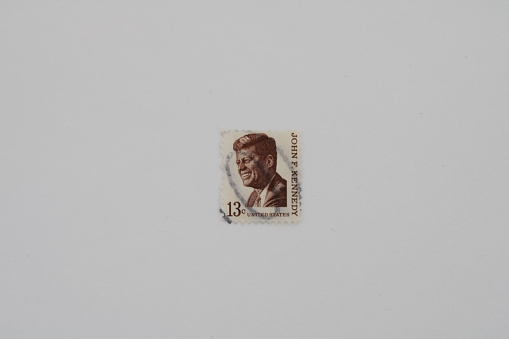 This brown and white, thirteen cent stamp depicts John F Kennedy