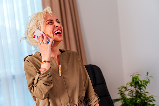laughing business woman in casuals talking on phone