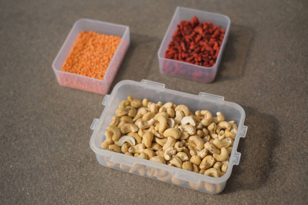High angle shots variety of healthy seeds and nuts on plastic container. There's red lentil, goji berry and cashew nuts.