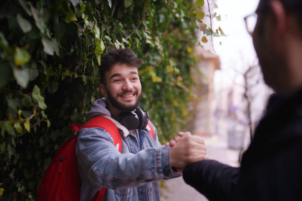 istock Young man hand shaking with a friend in street. 2088045184