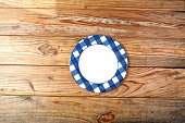 One empty plate on wooden picnic table