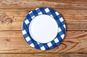 One empty plate on wooden picnic table