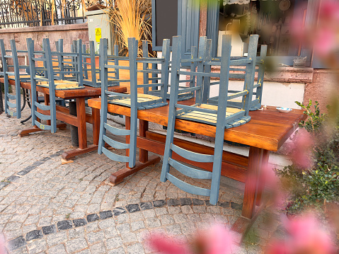 Tables and chairs of sidewalk cafe in old small town Ayvalik, Aegean Turkey