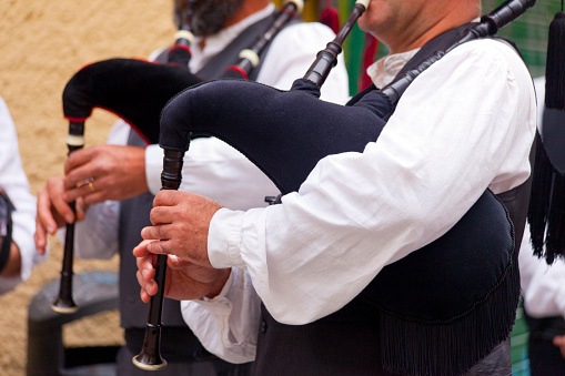 Pipers wearing traditional clothing, playing as they walk in a folk street band in a traditional festival, San Froilán in Lugo, Galicia, Spain.
