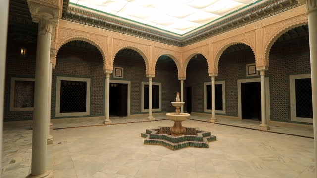 Courtyard of an Arabic mosque in Sbeitla with ornate arches and a fountain, daylight