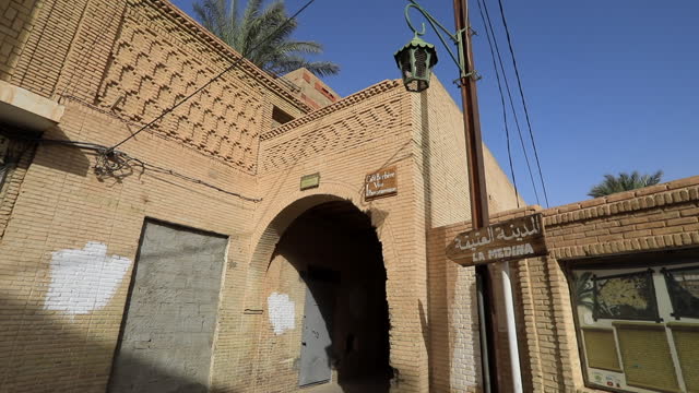 Sunlit view of a traditional Muslim street in Sbeitla with arched entryway
