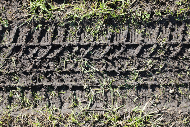 istock Mud tyre mark background. Tire track shape. Trail lines on black sand pattern. Road construction site backdrop. Heavy machinery imprint. 2088190146