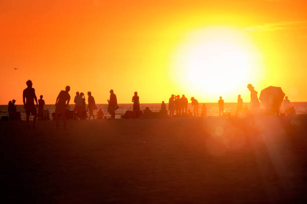 istock Silhouetted people enjoy beach holiday during sunset 2088200879