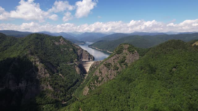 Vidraru dam in the fagaras mountains, a hydroelectric marvel amidst lush forests, aerial view