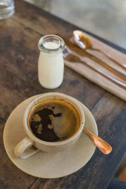 Fresh coffee and cream on wooden table