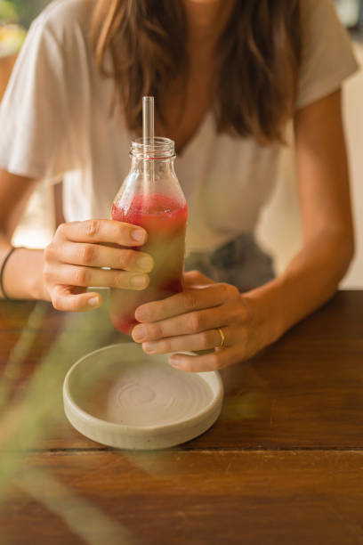 istock Young woman drinks fresh energy drink with eco-friendly straw 2088220184
