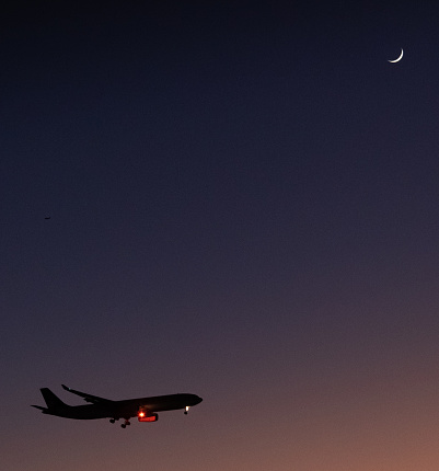 A plane about to touch down in Riyadh looking up at a new moon