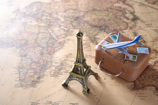 Diorama image of overseas travel using a world map, airplane, and model of the Eiffel Tower
