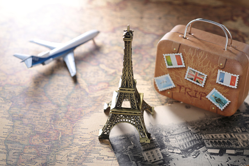 Diorama image of overseas travel using a world map, airplane, and model of the Eiffel Tower