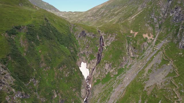 Verdant Fagaras Mountains embracing the Valea Rea Waterfall, aerial view