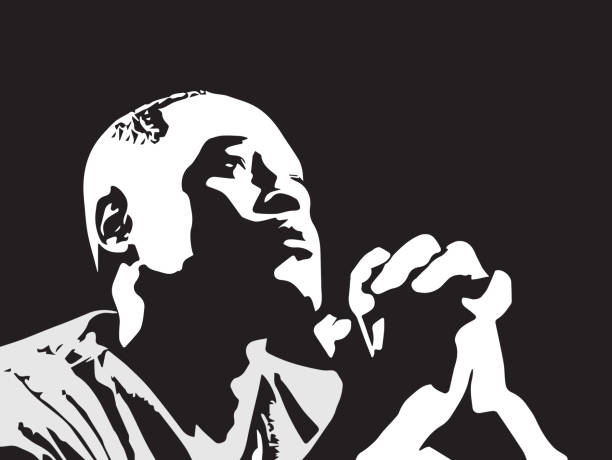 seorang pria kulit hitam menengadah ke langit, tangan tergenggam dan berdoa, dalam potret hitam putih ini - kontras tinggi ilustrasi stok