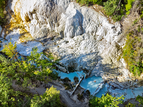Aerial view of the hot springs at Bagni San Filippo, it is a small hot spring containing calcium carbonate deposits, which form white concretions and waterfalls.