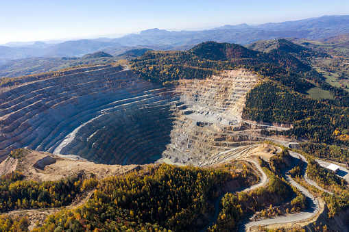 Flying above an open pit mine, copper excavation in Rosia Poieni, Romania. Aerial drone view