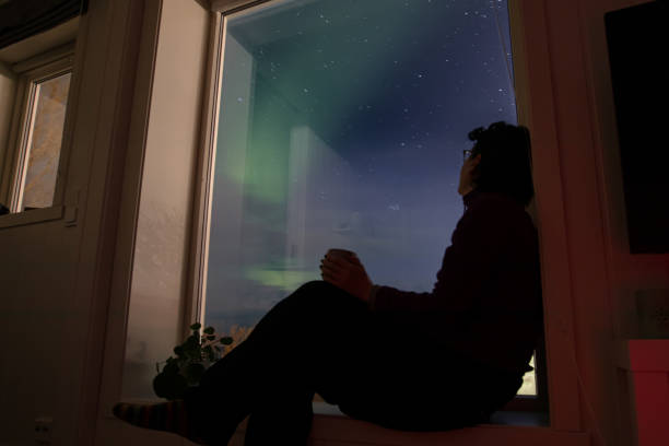 une jeune femme regarde les aurores boréales à la maison. - hammerfest photos et images de collection