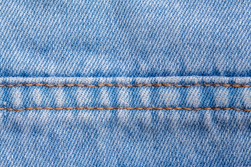 close up of stitching detail on light blue jeans