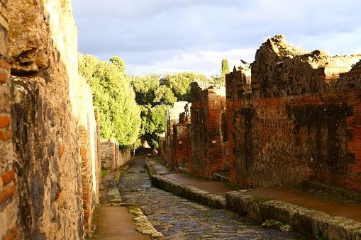 Cobbled streets of the city of Pompeii. Wet streets and cloudy skies. Ancient Roman city buried after the eruption of the Vesuvius volcano in 79AD