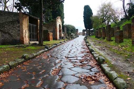 Cobbled streets of the city of Pompeii. Wet streets and cloudy skies. Ancient Roman city buried after the eruption of the Vesuvius volcano in 79AD