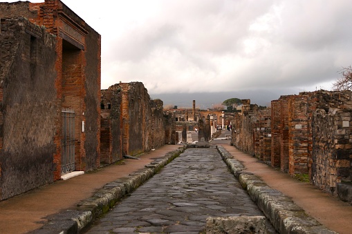 Cobbled streets of the city of Pompeii. Wet streets and cloudy skies. Ancient Roman city buried after the eruption of the Vesuvius volcano in 79AD