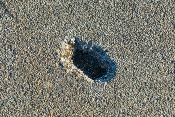istock Small hole in the asphalt. Hole in asphalt pavement close-up 2088438885
