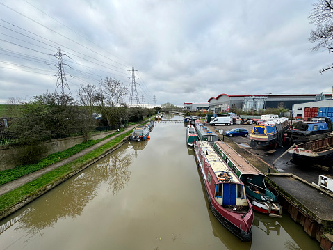Narrow boats on the River Lee Navigation in the Lee Valley Regional Park at Ponders End in Enfield, north London. March 2024
