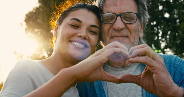 Father and daughter making a heart shape with their hands