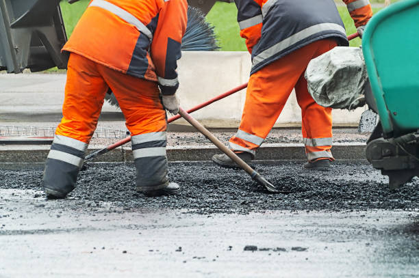 istock Two men in orange work clothes are shoveling asphalt 2088458959