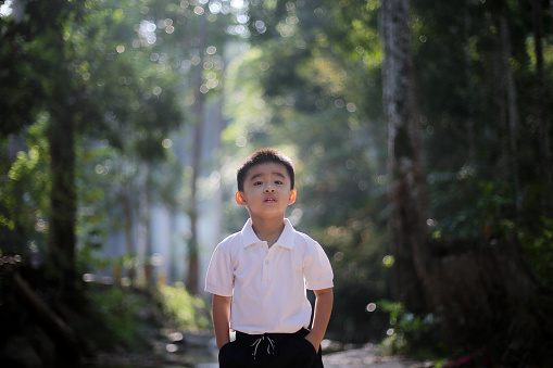 Portrait of an Asian young boy at nature reserve forest