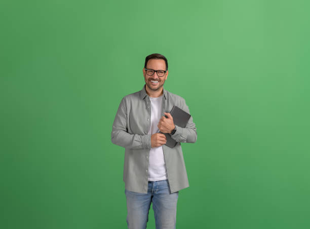 istock Handsome young entrepreneur with digital tablet posing confidently over isolated green background 2088473324
