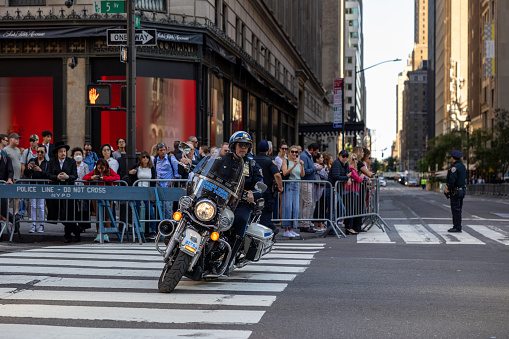Manhattan, New York, USA - September 20, 2023: An NYPD highway patrol officer on motorcycle checks an intersection on 5th Avenue for the passage of the presidential motorcade