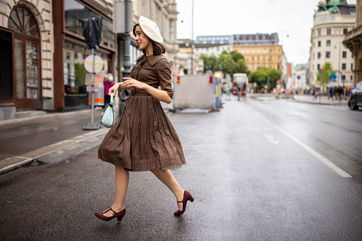 Fashionable young woman walking on the street in Vienna.