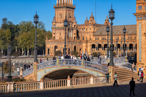 Seville, Andalusia, Spain - October 24, 2023: Plaza de Espana pavilion and bridge over canal in Maria Luisa Park, city landmark.