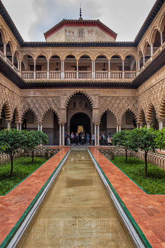 Seville, Spain - October 23, 2023: The Courtyard of the Maidens (Patio de las Doncellas) in Mudejar Palace of Royal Alcazar of Seville (Real Alcazar de Sevilla).