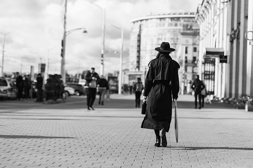 Woman in black hat and coat silhouette. Noir style. Thriller film concept