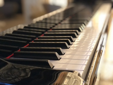 Side view of Piano keys with shallow depth of field. Classic grand piano keyboard background.