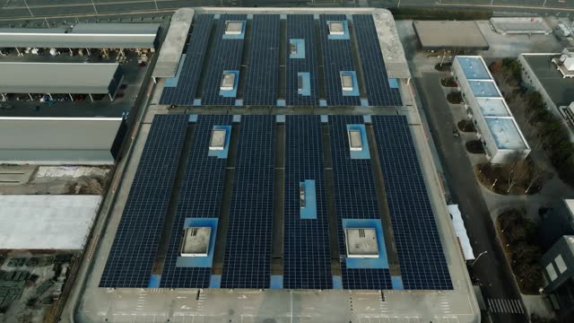 Aerial view of solar panels installed on factory rooftop