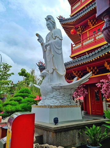 Jakarta, Indonesia - Mar 16, 2024: White Chinese Goddess statue standing in front of Pagoda in Pantai Indah Kapuk area - Jakarta.