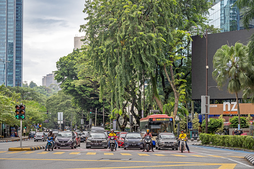 Kuala Lumpur, Malaysia - January 8th 2024:  Cars and motorcycles waiting for green light on a sunny day in the Malaysian capital