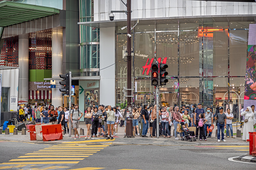 Kuala Lumpur, Malaysia - January 6th 2024:  Large group of people waiting to cross the street